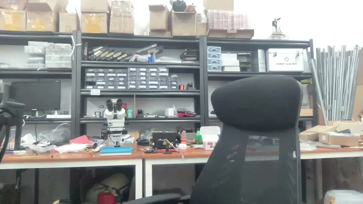 The workshop in Huaqiangbei with benches and parts shelves
